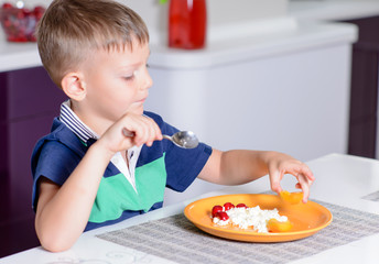 Young Boy Eating Plate of Cheese and Fruit