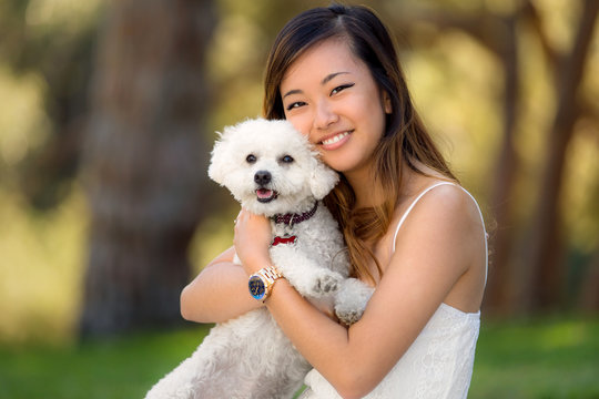 Small dog with owner girl at the park smiling and showing affection