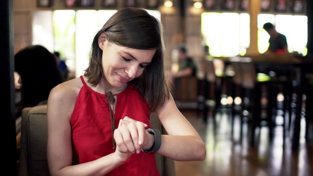 Pretty woman with smartwatch sitting in cafe
