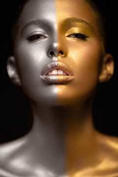 Beautyful girl with gold glitter on her face.Art image beauty face. Picture taken in the studio on a black background.