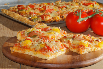 Pizza mit Paprika, Tomaten, Schinken, Zwiebeln, Käse