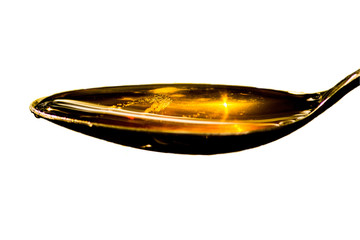 A spoon of honey over white background