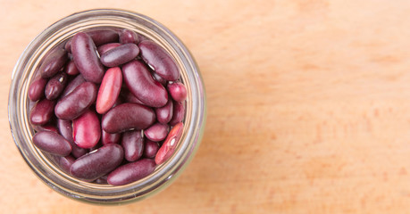 Red kidney beans in mason jar over wooden background