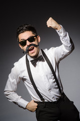 Young man with false moustache isolated on gray