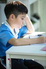 Young asian boy doing his homework