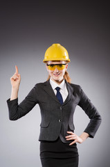 Female engineer with helmet isolated on gray