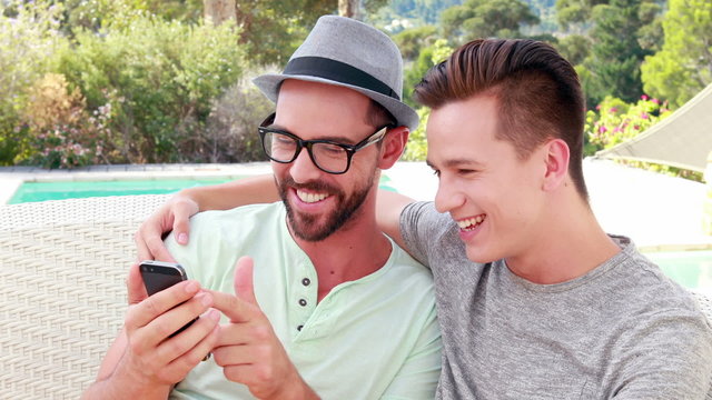 Happy homosexual couple on mobile phone 