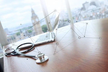 stethoscope and laptop computer on wood table and london bigben - obrazy, fototapety, plakaty