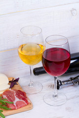 Glass and bottle of wine, cheese and prosciutto