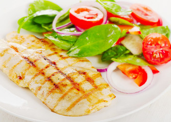 Salad with grilled chicken on a white plate.