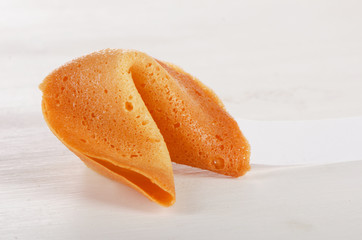 Fortune cookie with blank paper on a white background.