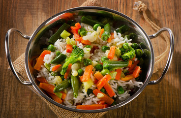 Rice with vegetables on  wooden background.