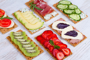 Fresh healthy appetizer snack with crispbread, fruits, berries, hamon and cheese