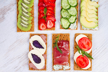 Fresh healthy appetizer snack with crispbread, fruits, berries, hamon and cheese