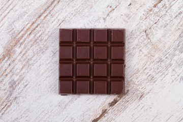 Chocolate bars and strawberries on wooden background