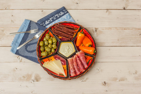 Basket with several Spanish tapas on white table