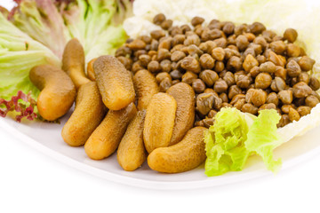 Marinated pickled cucumbers, capers and lettuce on plate