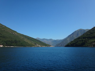 Морской залив с сине-голубой водой и побережье с горами