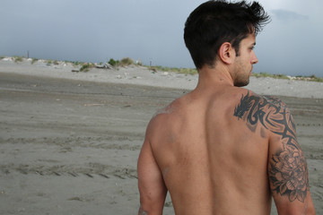 tattooed male on the sand