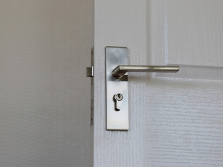 a metallic knob on white door horizontal