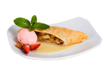 apple strudel with ice cream strawberries and mint on a square