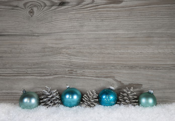 Weihnachtlicher Hintergrund mit Holz in grau und türkis blauen Kugeln 