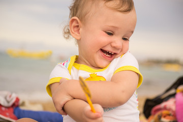 Small child with redness on the skin, suffering from food allergies by the sea