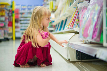 Fototapeta na wymiar Adorable girl select goods in supermarket