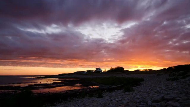 This colorful sunrise on the coast of Torekov in Sweden was recorded in a midsummer night. The massive clouds are changing the colors from blue over red and orange to yellow.
