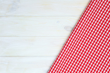 Obraz premium Red towel over wooden kitchen table. View from above with copy s