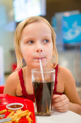 Adorable girl have meal with chicken,  soda drink and fried pota