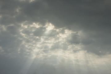 Light rays shine through the dark clouds
