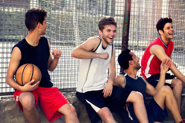 basketball players take a break sitting on a low wall