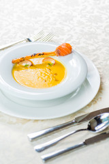 soup served with smoked salmon on a bread stick