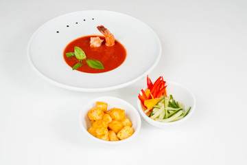 Tomato soup with shrimp served with vegetables on the side