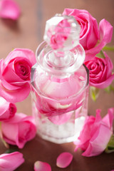 perfume bottle and pink rose flowers. spa aromatherapy