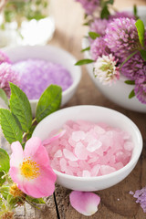 Obraz na płótnie Canvas spa with pink herbal salt and wild rose flowers clover