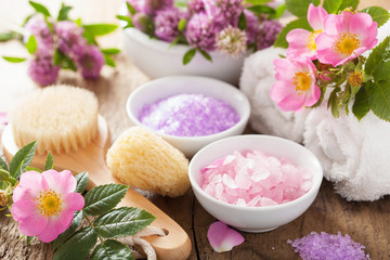 spa with pink herbal salt and wild rose flowers clover