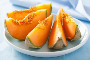 Fototapeta na wymiar cantaloupe melon sliced on blue plate