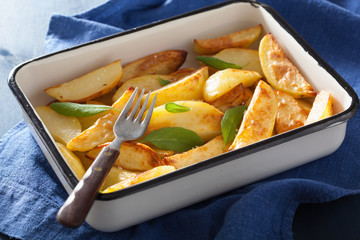 baked potato wedges in enamel baking dish