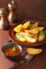 baked potato wedges in plate over brown rustic table