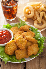 fast food chicken nuggets with ketchup, french fries, cola