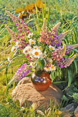 Bouquet with summer flowers on stone in garden