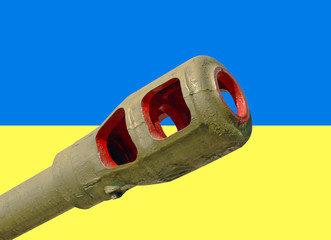 Artillery cannon taken closeup against of Ukrainian flag.