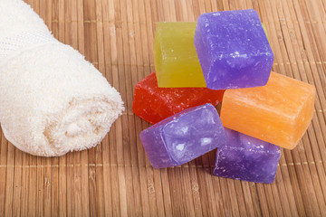 
colourful natural soap bars and towel on wooden background