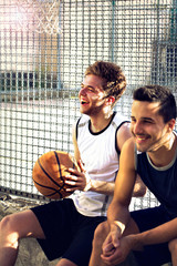 basketball players take a break sitting on a low wall