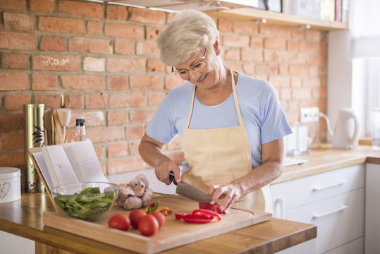 Senior Woman Cutting Vegetables.