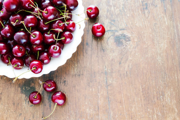 Fresh red cherries in bowl on a wooden table