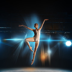 square photo of young blonde ballet dancer in jump on stage