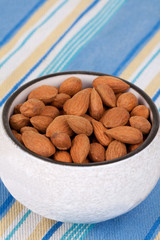 Almonds – A white bowl of almonds to snack on.